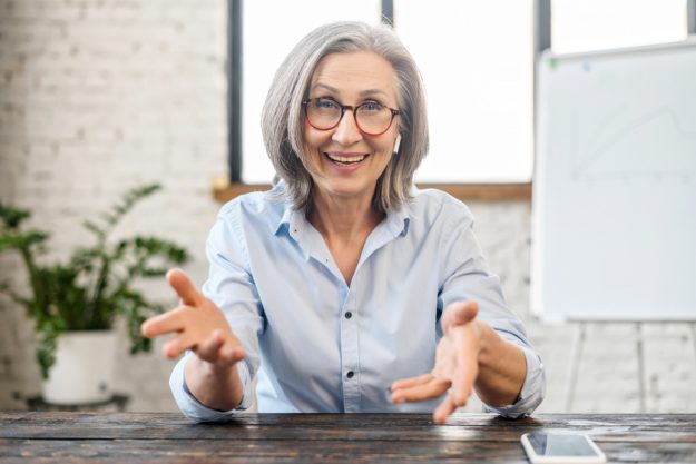Happy friendly senior female manager gesturing Happy friendly senior female manager gesturing