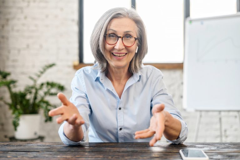 Happy friendly senior female manager gesturing