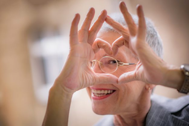 Cute senior old business woman making a heart shape with her han Can You Find Love After 50?
