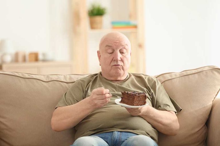 Fat senior man eating cake