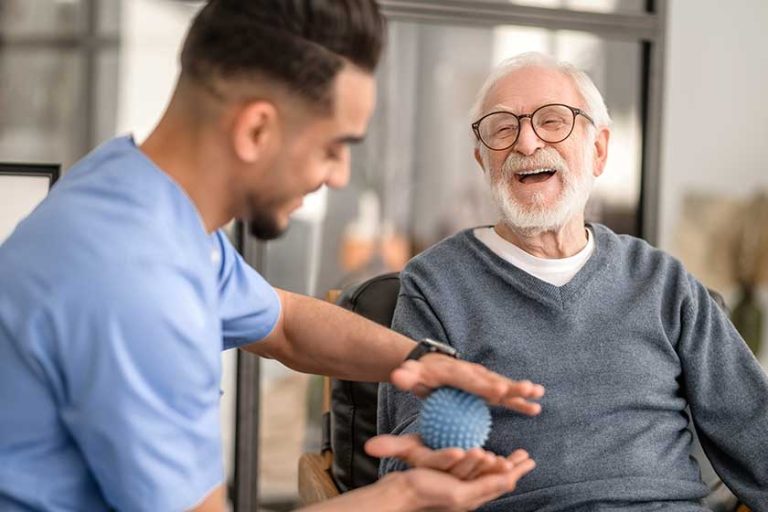 Patient having his hand massaged with a spiky massage ball