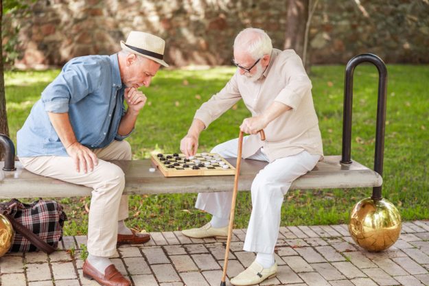 Two old gentlemen playing checkers in the park Best Things About Retiring In South Carolina