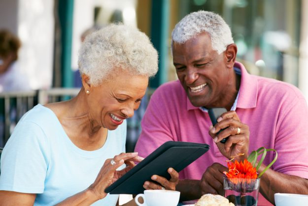 Senior Couple Using Tablet Computer At Outdoor Café 5 Tech Tools That Ease Your Life