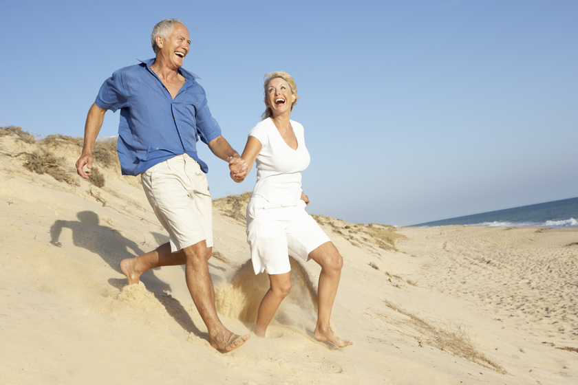Senior Couple Enjoying Beach Holiday Running Down Dune 4 Ways To Spend Your Golden Years Healthily And Happily
