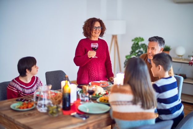 Beautiful family smiling happy and confident. One of them standing holding cup of wine speaking speech celebrating thanksgiving day at home The Top Assisted Living Dining Services In Cavetown, MD