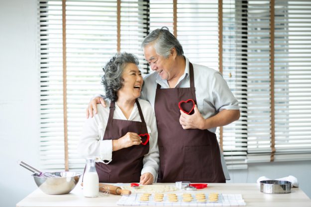 senior couple holding red cookies cutters in heart shape. Boring No More: Fun Activities for Seniors in York, PA Retirement Apartments
