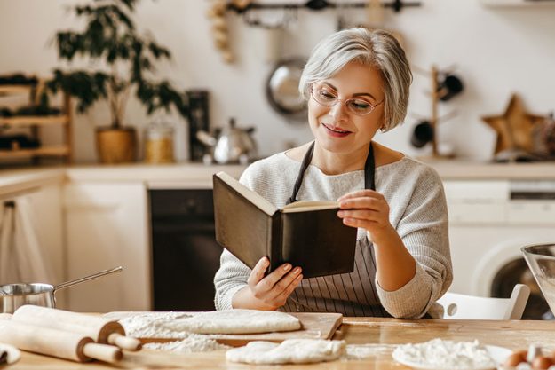 Happy old woman Granny cooks in kitchen Happy old woman Granny cooks in kitchen