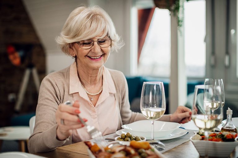 Happy senior woman enjoying while eating lunch