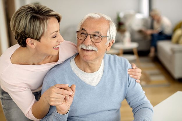 Happy woman and her senior father holding handS Happy woman and her senior father holding handS