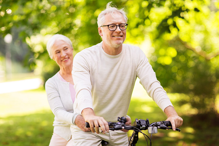 Happy senior couple riding bicycle at park Happy senior couple riding bicycle at park