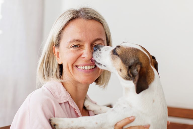 Happy woman is having fun with her Jack Russell terrier dog