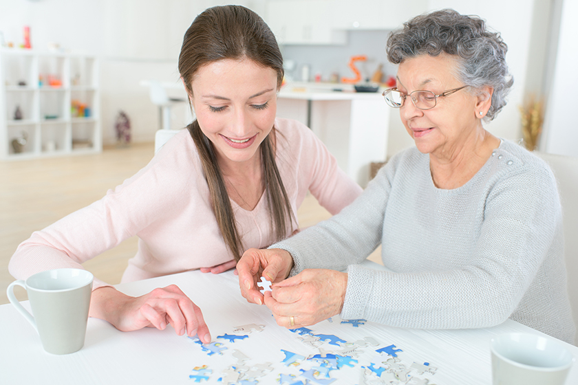 Granddaughter solving puzzle with the help of her grandmother Granddaughter solving puzzle with the help of her grandmother