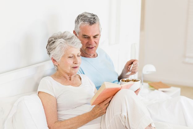 Happy senior couple at bed