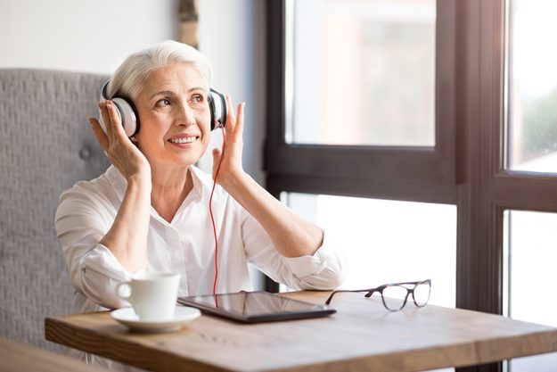Positive senior woman listening to music