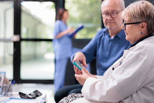 Senior medic taking patient insulin level test Senior medic taking patient insulin level test