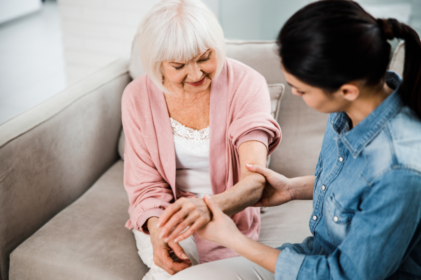 Family doctor holding arm of elderly woman Family doctor holding arm of elderly woman