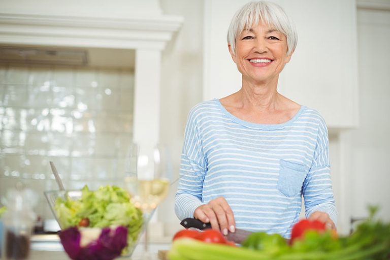 Senior woman preparing vegetable salad
