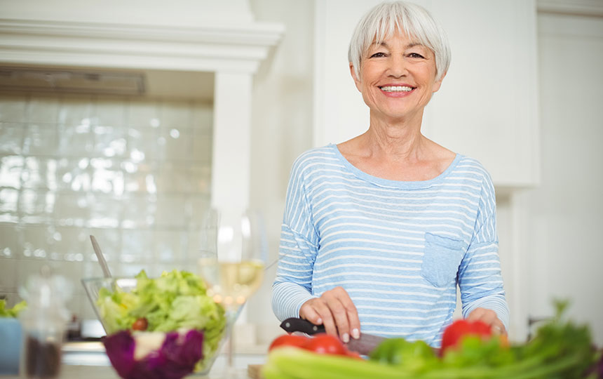 Senior woman preparing vegetable salad Senior woman preparing vegetable salad