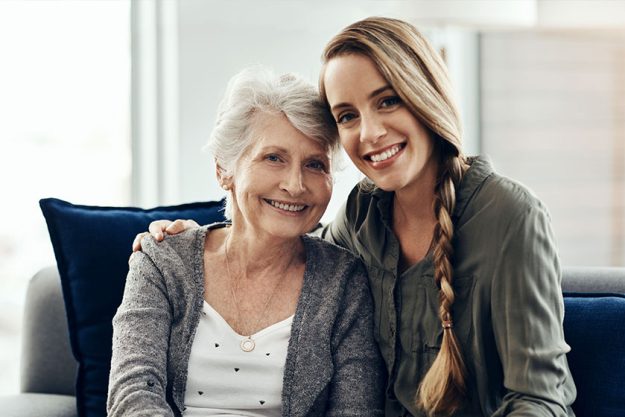 A senior woman and her adult daughter sitting together A senior woman and her adult daughter sitting together