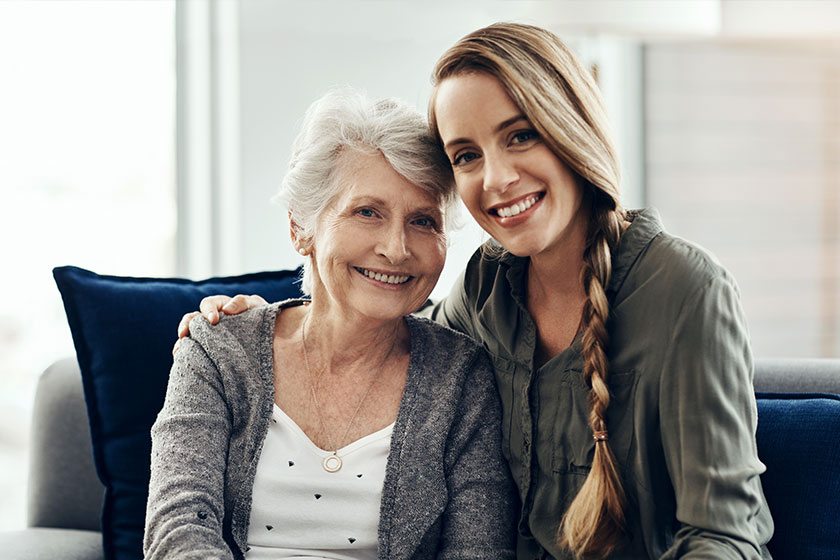 A senior woman and her adult daughter sitting together A senior woman and her adult daughter sitting together