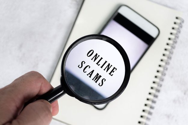 Man hand holds black magnifying glass handle smartphone background online