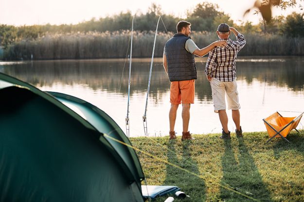 Back view senior man his son freshwater fishing lake while