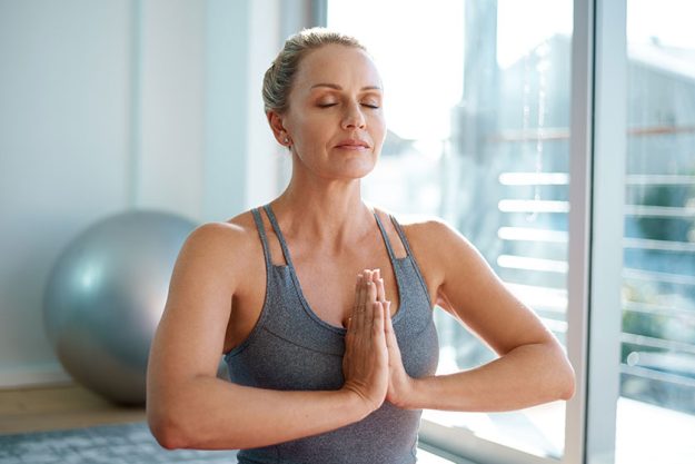 Perfect balance attractive mature woman meditating home Perfect balance attractive mature woman meditating home