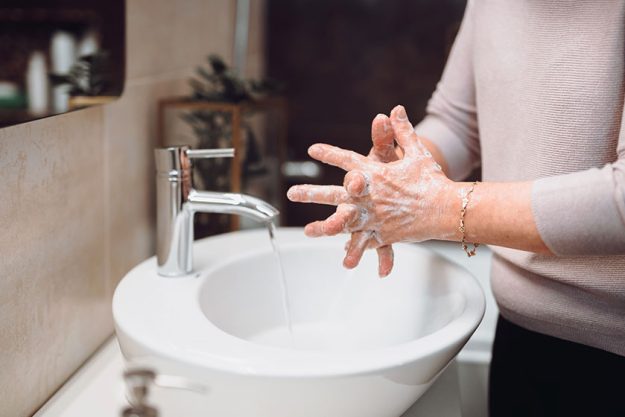 Elderly woman carefully washing hands Elderly woman carefully washing hands