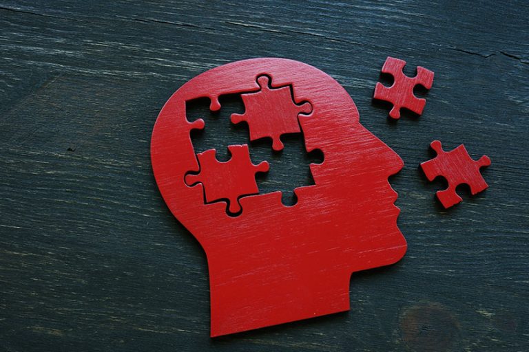 Human head shape with extracted puzzle pieces.