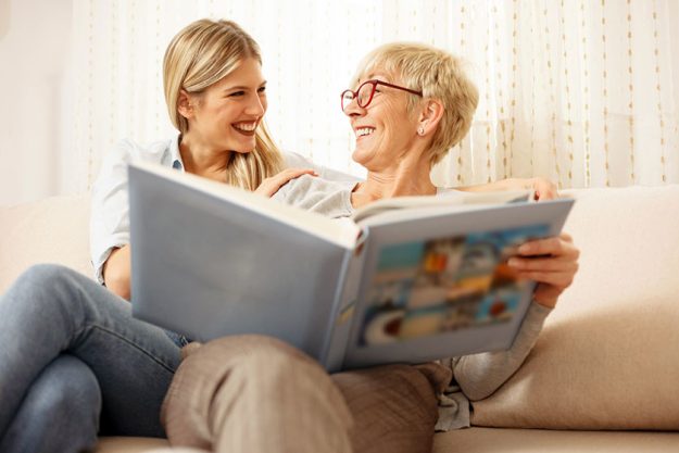 Mother and daughter looking at family photo album