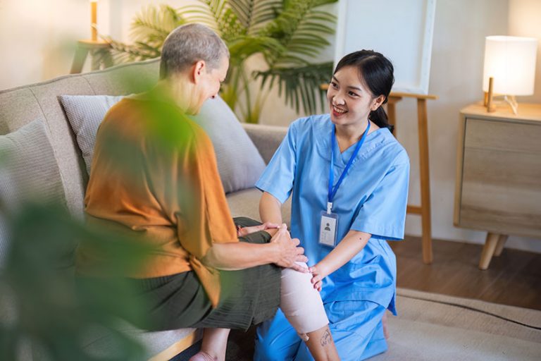 Physical therapist caregiver Asian and Caucasian senior woman