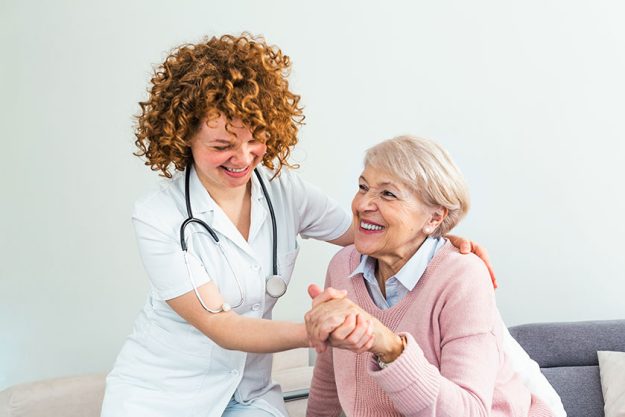 Young caring lovely caregiver and happy ward Young caring lovely caregiver and happy ward