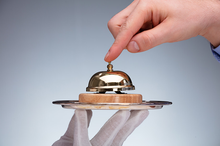 Close-up Of A Person's Hand Ringing Service Bell Hold By Butler