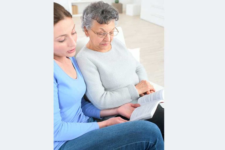 Grand daughter reading a book to her grandma