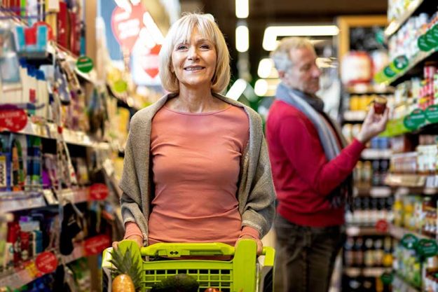 Attractive senior lady shopping with her husband at supermarket