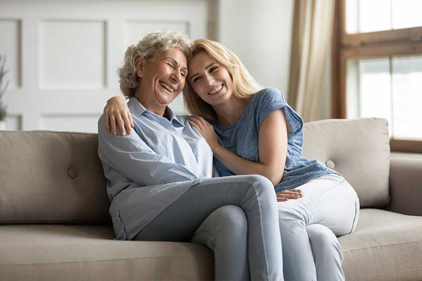 Happy young woman cuddling smiling older mature mommy.