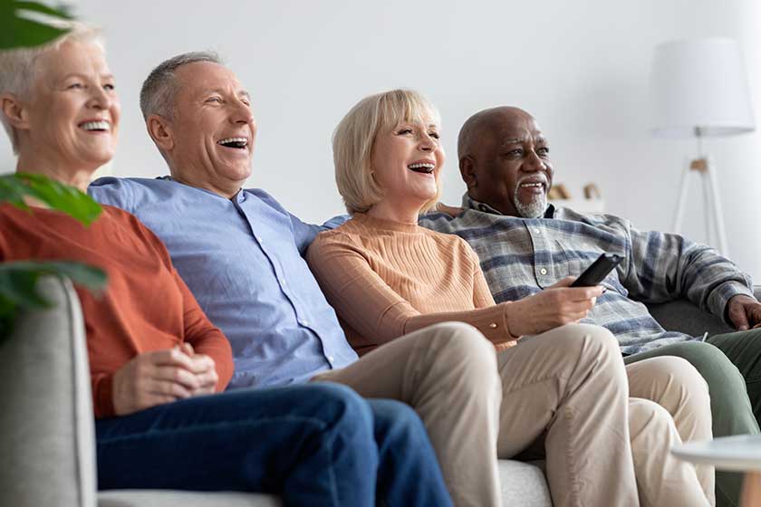 Multiracial friends senior people watching TV and laughing Multiracial friends senior people watching TV and laughing