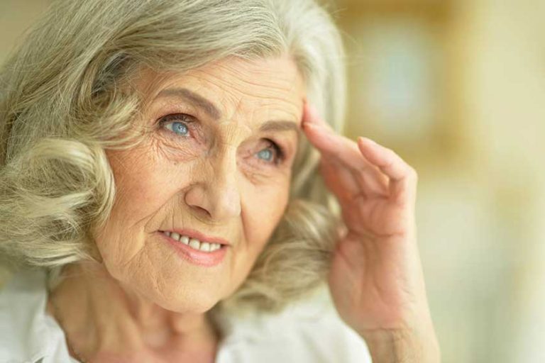 Portrait of smiling senior woman posing at home