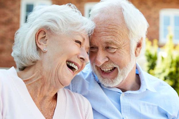Retired Couple Sitting On Bench And Talking In Assisted Living Facility Retired Couple Sitting On Bench And Talking In Assisted Living Facility