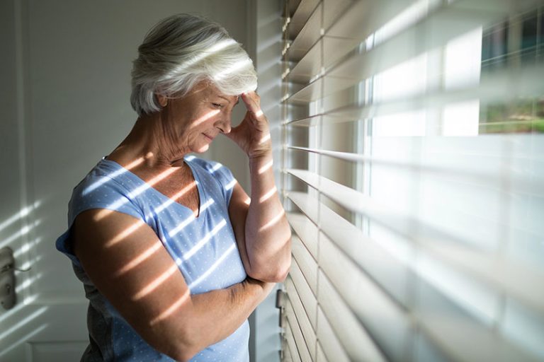 Tense senior woman near window