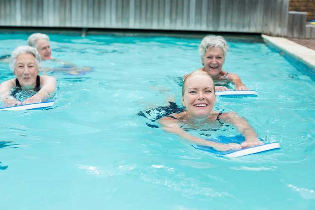 Women with kickboard swimming in pool Women with kickboard swimming in pool