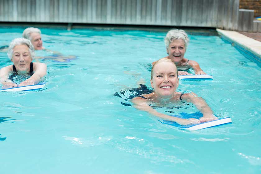Women with kickboard swimming in pool Women with kickboard swimming in pool