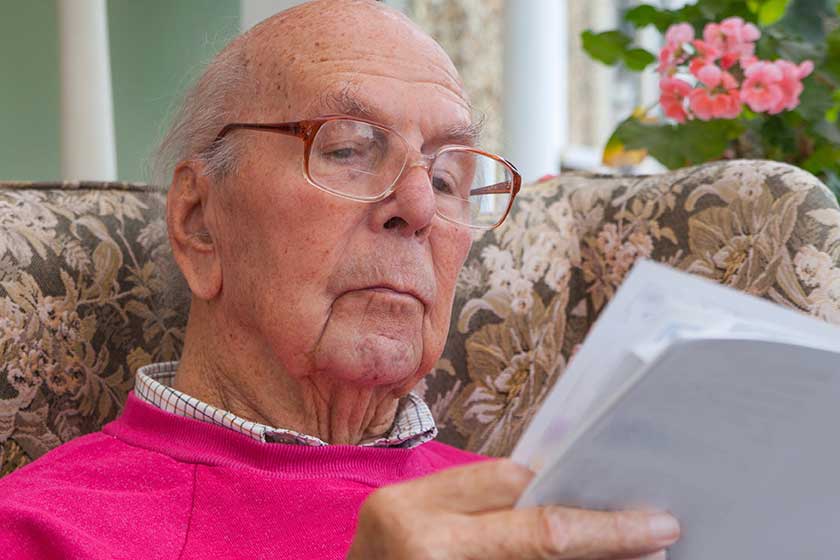 95 years old English man sitting in chair in domestic environment. Health and care concept
