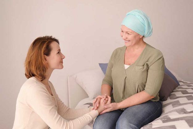 Young woman visiting her mother with cancer indoors
