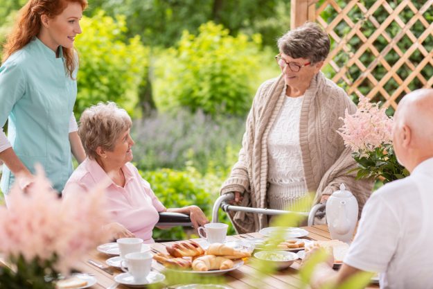 A,Group,Of,Pensioners,With,Their,Caregiver,Having,Breakfast,By
