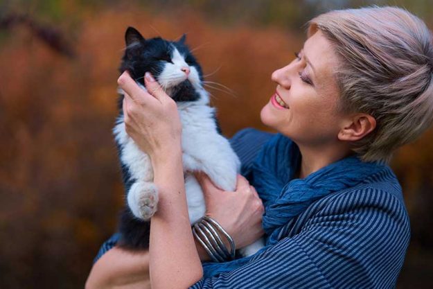 Beautiful-elegant-blond-woman-playing-with-cat-in-autumn