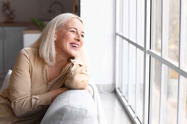 Morning-of-beautiful-mature-woman-sitting-on-sofa
