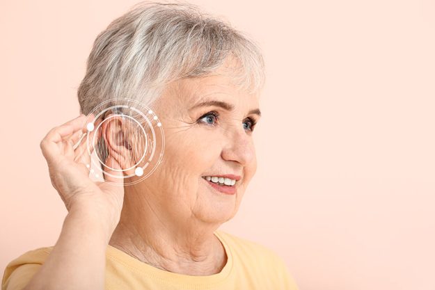 Senior-woman-with-hearing-aid-on-color-background Senior-woman-with-hearing-aid-on-color-background