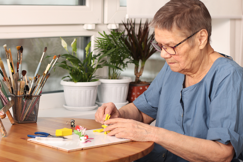 Active old age. An elderly woman sculpts small toys from polymer clay. Art therapy. the age of 80 years. A happy elderly person is engaged in creativity