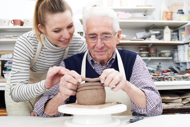 Senior Man With Teacher In Pottery Class Senior Man With Teacher In Pottery Class